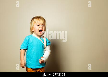 Screaming boy with broken hand in plaster cry Stock Photo