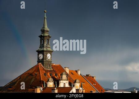 Dark sky with rain clouds over the historic city with a tower clock. Stock Photo