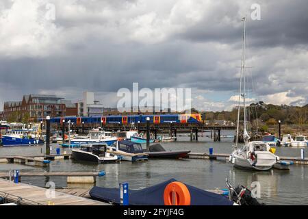 A South Western train travelling across the harbour bridge in Lymington Quay, Hampshire, England, UK Stock Photo