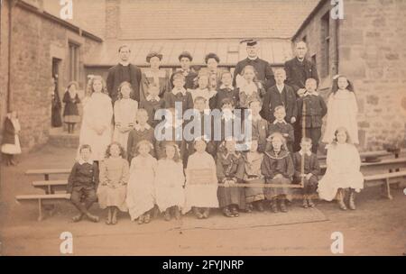 Vintage 1906 Edwardian photographic postcard of showing a group of school children and their teachers. The message on the board reads 'Band of Hope, Good attendance 1906' Stock Photo