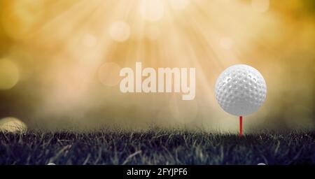 Composition of golf ball in grass on red tee and copy space Stock Photo