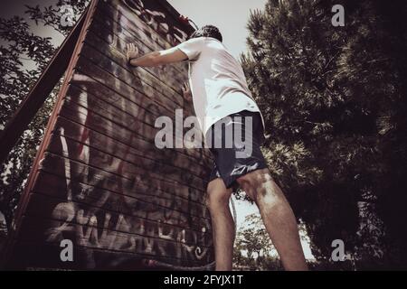 a man doing exercises in a park on a sunny day on shorts viewing his feet Stock Photo