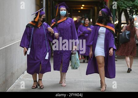 New York, USA. 27th May, 2021. Nurses from the class of 2021 walk down 69th street after graduating from Hunter College Nursing school and attending the first in-person ceremony since the fall of 2019, in New York, NY, May 27, 2021. The ceremony was also held virtually for those not able to participate, a limited number of guest were allowed to attend, and proof of a negative COVID-19 test taken within 72 hours test was required. (Photo by Anthony Behar/Sipa USA) Credit: Sipa USA/Alamy Live News Stock Photo