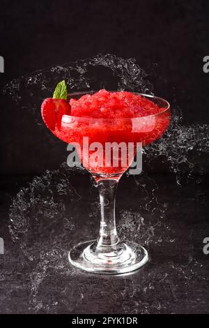 Strawberry margarita cocktail splash in glass on black slate background Stock Photo