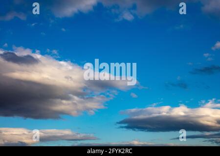 Blue sky with few fluffy clouds concept. Overcast with sunset, sunrise on blue sky as background. Colorful bright horizon, abstract, copy space, wallp Stock Photo