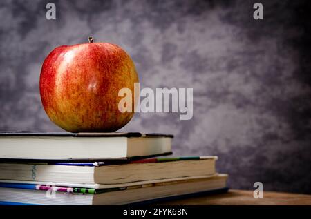 Red Apple On Top Of Books In Classroom Stock Photo