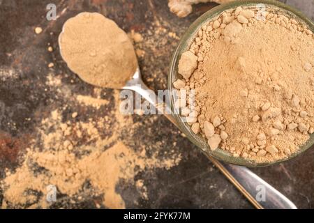 Ginger in the glass jar and on a spoon on the dark background Stock Photo