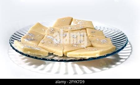 Kaju Katli is a Diamond shape Indian sweet made using cashew sugar and mava, served in a plate isolated on white background. selective focus Stock Photo