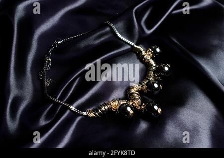 necklace with black beads on silk background Stock Photo