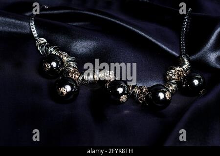 necklace with black beads on silk background Stock Photo