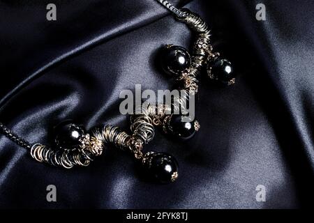 necklace with black beads on silk background Stock Photo