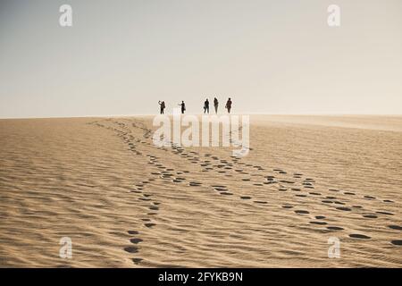 Nouadhibou, Mauritania, JANUARY 18, 2020: Group of people on top of a mountain in the desert Stock Photo