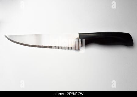 Very sharp serrated chrome metal knife with plastic handle, isolated on white background Stock Photo