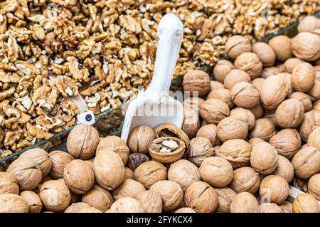 Walnut kernels and whole walnuts are sold at the grocery store Stock Photo