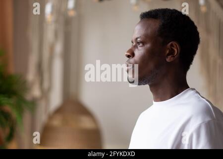 African man standing at home alone planning future day Stock Photo