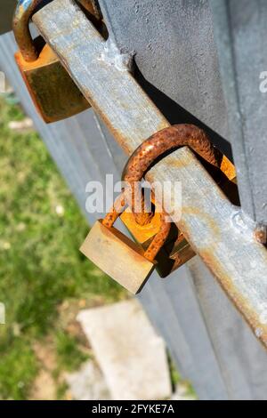 Two rusty old linked padlocks on a bridge beam as a symbol of love and devotion. The concept of eternity and happiness forever Stock Photo