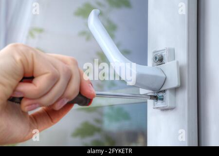 On double hung window, dismantle handle to supply restrictor that adjusts width of opening. Stock Photo