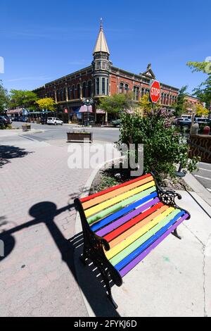 Ellensburg, WA, USA - May 26, 2021; Corner of 4th and Pearl in Ellensburg featuring the Davidson building and a rainbow painted bench Stock Photo