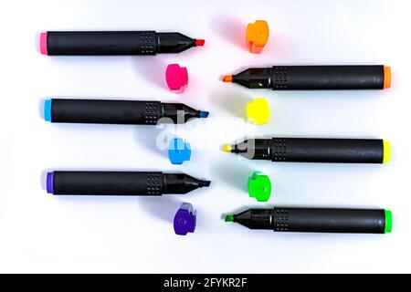 Set of uncovered color-ordered highlighters facing each other on white background. Stock Photo