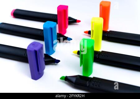 Set of uncovered color-ordered highlighters facing each other on white background. Stock Photo