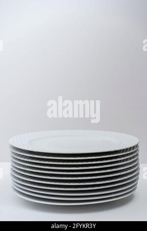 Set of washed stacked white dishes on a white table. Stock Photo
