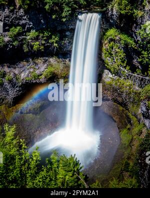 Rainbow at the base of a smooth looking Brandywine Falls at the Sea to Sky Highway between Squamish and Whistler, British Columbia, Canada Stock Photo