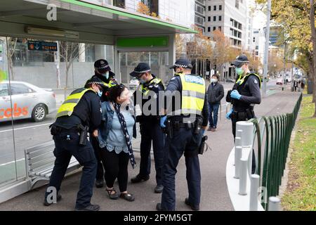Melbourne, Australia 29 May 2021,  A woman is arrested for refusing to give her details during a planned 'Millions March' rally at Flagstaff Gardens, that had been canceled by organisers due to the snap lockdown. Hardcore anti-lockdown and anti-vaccination protesters still attend the park and rallied against the government. Credit: Michael Currie/Alamy Live News Stock Photo