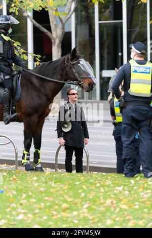 Melbourne, Australia 29 May 2021, A protest leader 'Harrison' is detained by police during a planned 'Millions March' rally at Flagstaff Gardens, that had been canceled by organisers due to the snap lockdown. Hardcore anti-lockdown and anti-vaccination protesters still attend the park and rallied against the government. Credit: Michael Currie/Alamy Live News Stock Photo