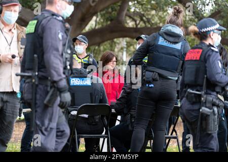 Melbourne, Australia 29 May 2021, A protester in red is processed by police officers in the park during a planned 'Millions March' rally at Flagstaff Gardens, that had been canceled by organisers due to the snap lockdown. Hardcore anti-lockdown and anti-vaccination protesters still attend the park and rallied against the government. Credit: Michael Currie/Alamy Live News Stock Photo