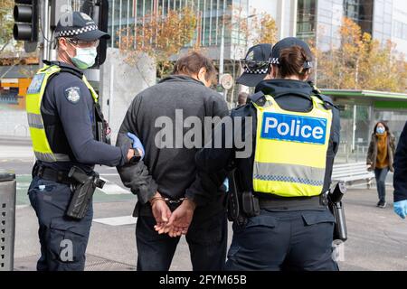 Melbourne, Australia 29 May 2021, police arrest a protester near the gardens during a planned 'Millions March' rally at Flagstaff Gardens, that had been canceled by organisers due to the snap lockdown. Hardcore anti-lockdown and anti-vaccination protesters still attend the park and rallied against the government. Credit: Michael Currie/Alamy Live News Stock Photo