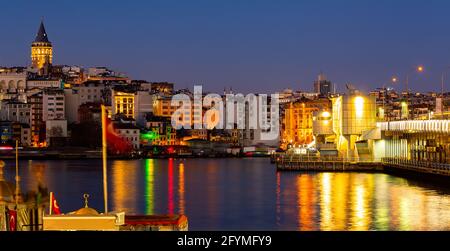 Scenic view of lighted Karakoy quarter and Galata Tower from Golden Horn Bay in winter twilight, Istanbul, Turkey Stock Photo