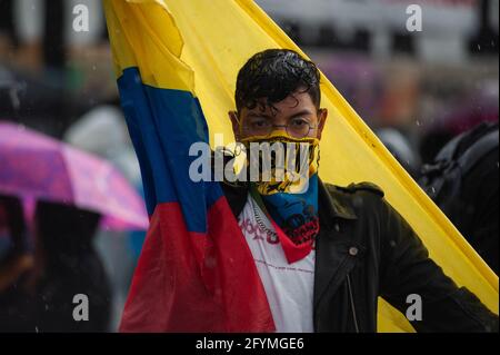 Bogota, Colombia. 28th May, 2021. A demonstrator poses for a photo while wearing a scarf of the Colombian flag and the word 'Resist' and carries another Colombian flag as thousands gathered to protest against the president of Colombia Ivan Duque Maraquez and the cases of unrest and police brutality that had left at least 45 dead during the first month of demonstrations, in Bogota, Colombia on May 28, 2021. Credit: Long Visual Press/Alamy Live News Stock Photo