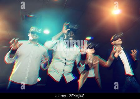 Multinational group of colleagues using VR glasses during team building seminar Stock Photo