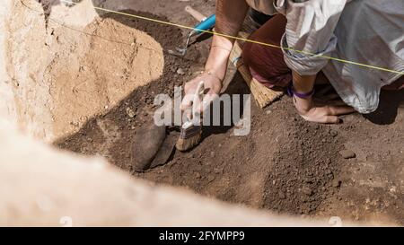 Archaeologist excavating pottery Stock Photo