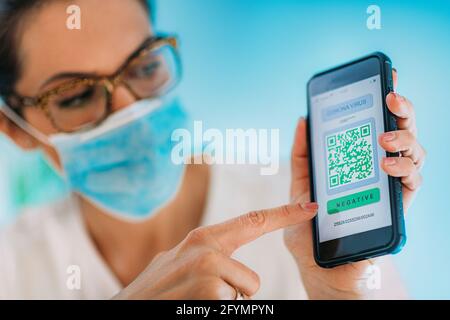Woman showing smartphone confirming covid-19 status Stock Photo