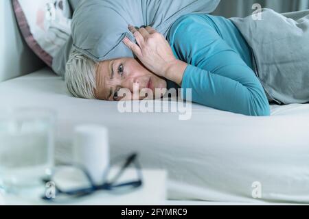 Noise keeping woman awake Stock Photo