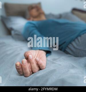 Woman lying in bed meditating Stock Photo