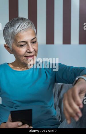 Senior woman checking smart watch sleep tracker Stock Photo