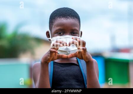 Girl in face mask making heart sign Stock Photo