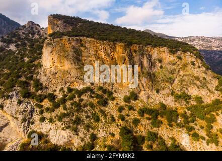 View of hundreds of burial tombs carved into mountainside in ancient Lycian city of Pinara in Turkey Stock Photo