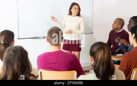 Adult lecturer talking to students during seminar Stock Photo