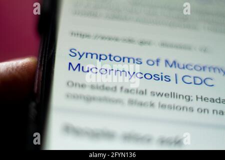 mucormycosis News on the phone.Mobile phone in hands. selective focus and chromatic aberration effects. Stock Photo