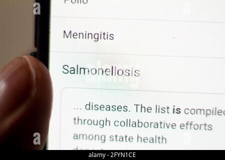 salmonellosis News on the phone.Mobile phone in hands. selective focus and chromatic aberration effects. Stock Photo