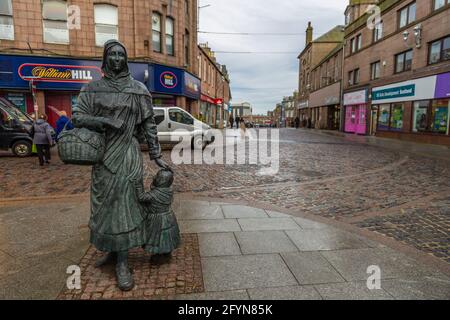 Peterhead, Scotland, UK - 05 February 2016: Sculpture of a woman with a little girl in the main square of the city. Cloudy day. Stock Photo