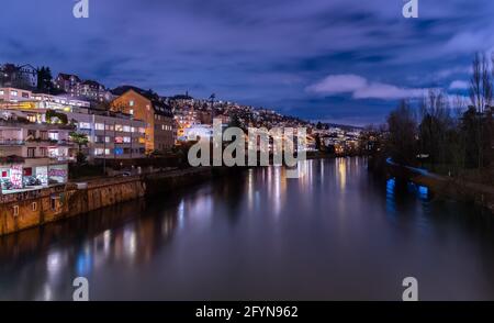 Zurich, Switzerland - February 5, 2021: Blue hour in Zürich, the largest city in Switzerland. Illuminated houses along the Limmat River and their refl Stock Photo