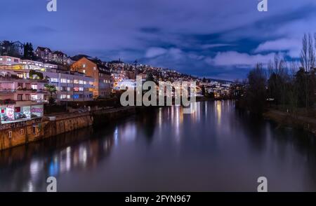 Zurich, Switzerland - February 5, 2021: Blue hour in Zürich, the largest city in Switzerland. Illuminated houses along the Limmat River and their refl Stock Photo