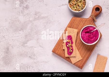 Vegetarian, vegan snack - beetroot hummus, sprouted grains and whole grain crisps. Stock Photo