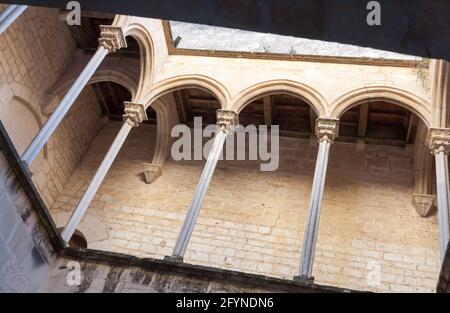 Gothic arched gallery with porphyry columns leading on royal residence in Monastery of Santa Maria de Santes Creus, Aiguamurcia, Spain Stock Photo