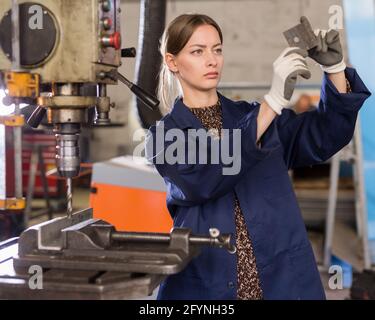 Portrait of confident  woman  mechanic using drilling machine  in workshop Stock Photo