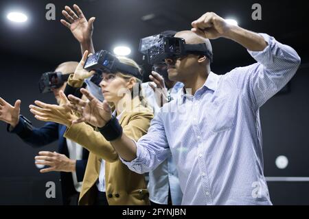 Multiethnic friends using virtual reality glasses  -  people having fun with new technology vr headset - Main focus on woman - New tech trends concept Stock Photo